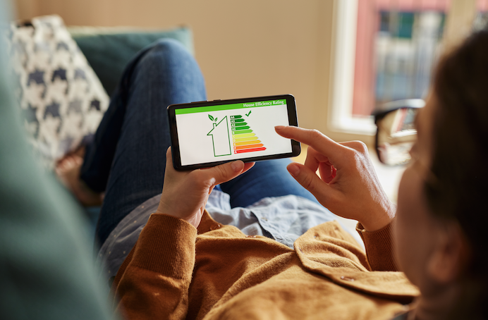 Un homme est allongé dans un fauteuil et vérifie numériquement le caractère écologique d'un achat groupé chez Wikipower.